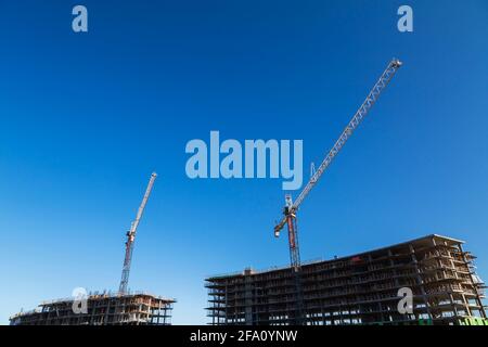 Grues de travail de tour sur le site de construction de condominium résidentiel Banque D'Images