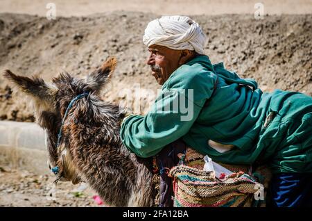 Midelt, Maroc - 11 avril 2015. Un vieil homme handicapé qui se déplace sur l'âne et supplie pour de l'argent Banque D'Images
