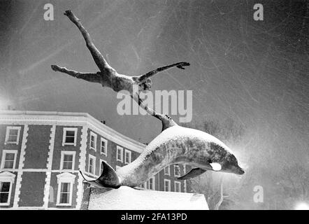 « Boy with Dolphin » - sculpture en bronze de David Wynne - une nuit enneigée en janvier 1982. Oakley Street, Londres. Banque D'Images