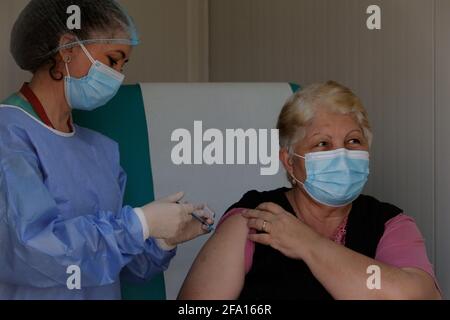 Bucarest, Roumanie. 21 avril 2021. Une femme reçoit une dose du vaccin COVID-19 lors de l'inauguration d'un centre de vaccination mobile près de Bucarest, Roumanie, le 21 avril 2021. Credit: Cristian Cristel/Xinhua/Alay Live News Banque D'Images