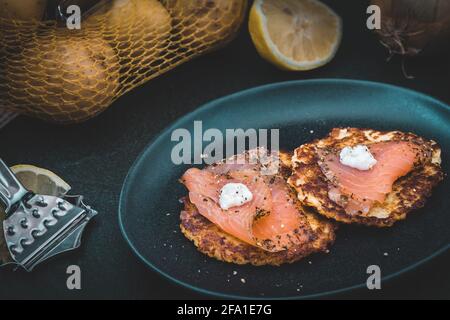 Crêpes de pommes de terre au saumon fumé sur fond sombre Banque D'Images