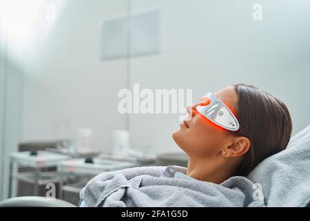 Femme en lunettes subissant une procédure cosmétique Banque D'Images
