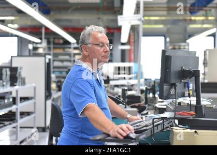 En micro-électronique de l'ingénierie : les travailleurs dans la production et l'assemblage de composants électroniques de haute technologie dans une usine moderne Banque D'Images