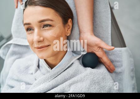 Client spa avec des taches sous les yeux rêvant de jour pendant une procédure cosmétique Banque D'Images