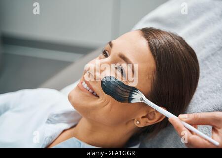 Femme souriant au cours d'une procédure cosmétique Banque D'Images