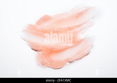 Échantillon de produit cosmétique texture de gel crémeuse taches sur fond blanc. Gommage cosmétique rose texturé pour le visage et le corps - image Banque D'Images