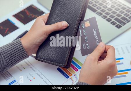 Femme d'affaires mains tenant portefeuille en cuir avec cartes de crédit sur le bureau. Concept affaires, finances et argent. Banque D'Images