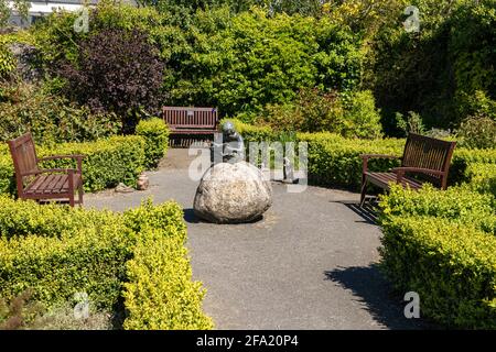La paix et la tranquillité, d'une statue commémorative de Boy Reading in The Secret Memorial Garden, Great Torrington, Devon, UK. Banque D'Images