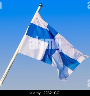 Drapeau de la Finlande flottant sur le vent contre un ciel bleu clair. Banque D'Images