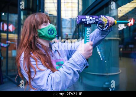 Canary Wharf, Londres, Royaume-Uni 22 avril 2021 extinction les femmes de la rébellion brisent les fenêtres de la banque HSBC dans le cadre d'une série d'actions qui composent la rébellion monétaire. Le groupe environnemental est en colère contre les investissements de 80 milliards de livres de la banque dans les combustibles fossiles au cours des 5 dernières années Banque D'Images