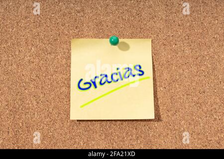 Merci mot en espagnol sur note jaune sur liège carte Banque D'Images