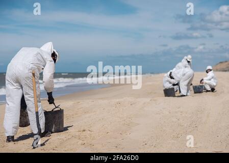 Concept: Nettoyage de la côte. Groupe de personnes méconnues. Les travailleurs nettoyant la plage après un déversement de carburant. Parc naturel. Banque D'Images