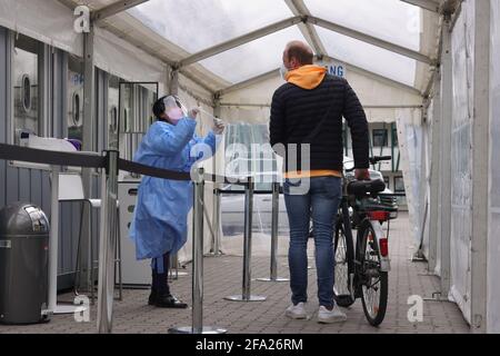 22 avril 2021, Hambourg: Un passant conduit à vélo pour des essais rapides à Hambourg-Eimsbüttel. Dans le centre d'essai sur le terrain d'un club sportif jusqu'à 600 personnes avec et sans vélo peut être testé pour Corona. Photo: Ulrich Perrey/dpa Banque D'Images