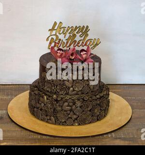 Gâteau de mariage au chocolat à deux niveaux avec surmatelas et orchidée Banque D'Images