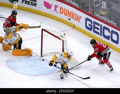 Chicago, États-Unis. 21 avril 2021. Le disque des Blackhawks de Chicago, Philipp Kurashev (23), passe devant le défenseur des prédateurs de Nashville, Mattias Ekholm (14) et à travers l'embouchure du but en tant que gardien de prédateurs, Juuse Saros (74) et le centre des Blackhawks de Chicago, Ryan Carpenter (22), à la deuxième période au United Center de Chicago, mercredi, 21 avril 2021. (Photo par Terrence Antonio James/Chicago Tribune/TNS/Sipa USA) crédit: SIPA USA/Alay Live News Banque D'Images