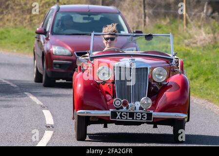 Vent dans la voiture de cheveux, homme conduisant une voiture de sport classique rouge MG, Alresford, Hampshire, Royaume-Uni Banque D'Images