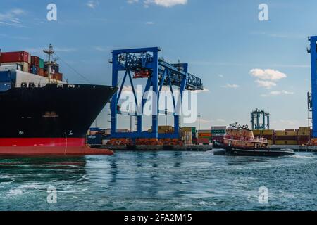 Boston, ma, États-Unis - 11 mars 2019 : navire-conteneur entièrement chargé quittant Boston Harbor avec remorqueurs et grues d'expédition en arrière-plan. Banque D'Images