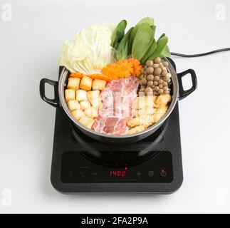 table de cuisson à induction avec pot sukiyaki isolé sur fond blanc Banque D'Images