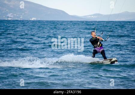 Un kiteboarder est tiré à travers l'eau porter une combinaison dedans eaux douces à froides Banque D'Images