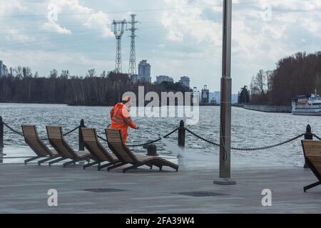 Moscou, Russie - avril 22 2021 : un employé de la ville nettoie le remblai à l'aide d'un équipement d'eau à haute pression. Banque D'Images