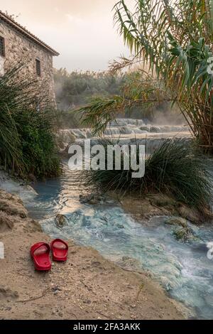 Cascate del Mulino, deux pantoufles rouges à gauche au bord des piscines naturelles d'eau thermale. Saturnia, Grosseto, Toscane, Italie, Europe Banque D'Images