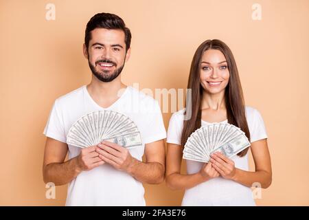 Photo de charmant couple marié habillé blanc t-shirts tenue grande argent argent isolé couleur beige arrière-plan Banque D'Images