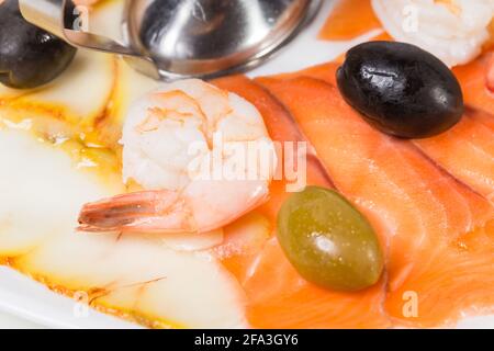 Délicieux plat de saumon fumé garni de crevettes et d'olives. Macro. La photo peut être utilisée comme arrière-plan entier. Banque D'Images