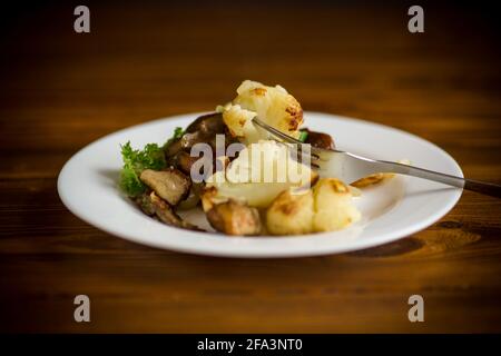 chou-fleur frit avec des champignons porcini sauvages et des oignons dans un plaque Banque D'Images