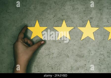 Concept d'expérience client. Trois étoiles jaunes sur fond de béton. Feedback négatif - sélection manuelle d'un 3 étoiles Banque D'Images