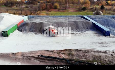 Varsovie, Pologne 04.10.2019 - chargeur frontal sur roues fonctionnant avec du gravier. Vue aérienne de drone sur le chantier de construction de routes près de Varsovie, Pologne. Banque D'Images