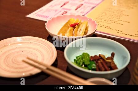 Accent sélectif sur un petit bol de pesora-zuke, plat traditionnel d'aubergines marinées de la région de Yamagata au Japon, sur une table en bois Banque D'Images