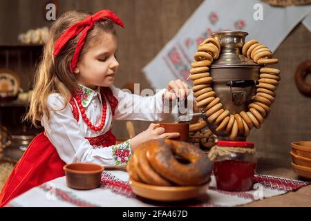 Adorable fille versant le thé du samovar Banque D'Images