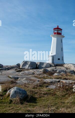 Un sentier rocailleux entre de grands blocs rocheux menant à un grand phare rond de tour blanc d'époque avec tour de guet rouge Au sommet près de l'Atlantique Banque D'Images