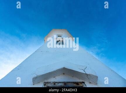 La vue vers le haut de la salle de montre ou du haut d'un phare de forme octogonale. Il y a deux petites fenêtres dans le bâtiment en béton blanc Banque D'Images