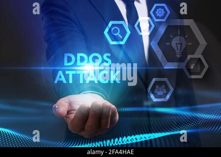 Concept commercial, technologique, Internet et réseau. Jeune homme d'affaires travaillant sur un écran virtuel du futur et voit l'inscription: Attaque DDoS Banque D'Images