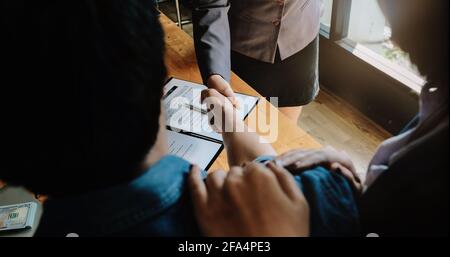 Au-dessus de la vue du couple marié et de l'agent immobilier sympathique qui se secoue après avoir fait affaire immobilière à l'intérieur, au-dessus de la vue. Banque D'Images