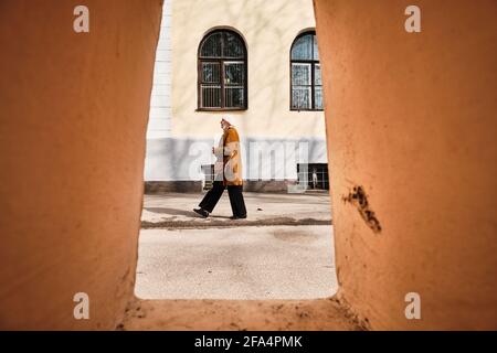 Novgorod, Russie, Aleksandr Kirillov - 04232021: 'Une femme âgée dans un masque marche dans la rue' Banque D'Images