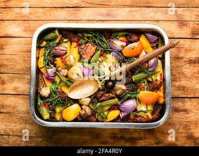 Viande et légumes grillés sur fond de bois rustique. Viande rôtie avec légumes dans le plateau Banque D'Images