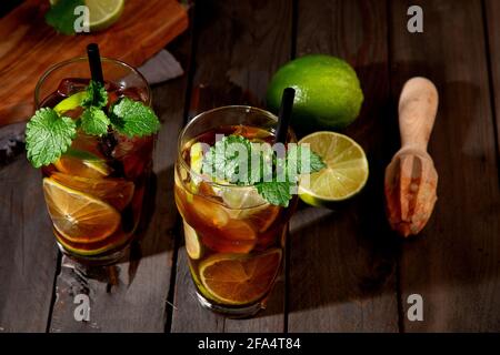 Cocktail Cuba libre de longdrink frais sur fond sombre. Panorama Banque D'Images