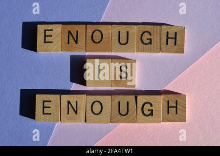 Assez est, expression en lettres de l'alphabet de bois isolées sur fond rose et violet Banque D'Images