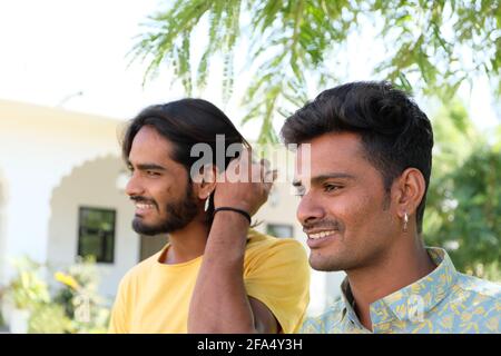 Joyeux sourire jeune Indien gay couple marchant dans un parc Banque D'Images