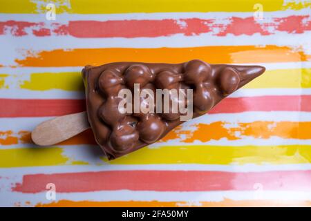 dessert au chocolat avec noix sur un bâton sur fond lumineux. Banque D'Images