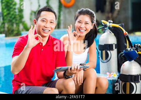 Les gens d'Asie au cours de plongeur en vacances avec wetsuit et tablet computer Banque D'Images