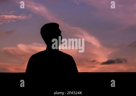 Silhouette d'homme asiatique rester seul avec fond de ciel crépuscule. Dépression et santé mentale. Banque D'Images