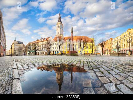 Swidnica, Pologne. Panorama de la place du marché (Rynek) avec bâtiment de l'hôtel de ville historique se reflétant dans la flaque Banque D'Images