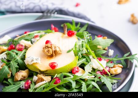 Salade fraîche et saine avec arugula, fromage gorgonzola, grenade et poires. Banque D'Images