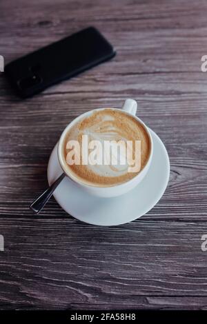 café chaud ou cappuccino chaud sur fond de bois, art latte Banque D'Images
