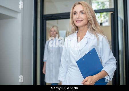Femme médecin réussie dans le couloir et collègue Banque D'Images