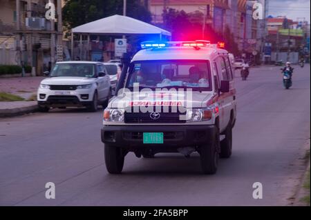 En raison d'une récente épidémie de COVID - 19 dans les marchés et les usines de vêtements, le gouvernement cambodgien a imposé un verrouillage. Ici, une ambulance antique s'accélère dans une rue dans une zone rouge / zone à haut risque, après un site d'essai, Prise d'un patient positif COVID - 19 à l'hôpital le plus proche pendant la pandémie du coronavirus. Stueng Meanchey, Phnom Penh, Cambodge. 23 avril 2021. © Kraig Lieb Banque D'Images