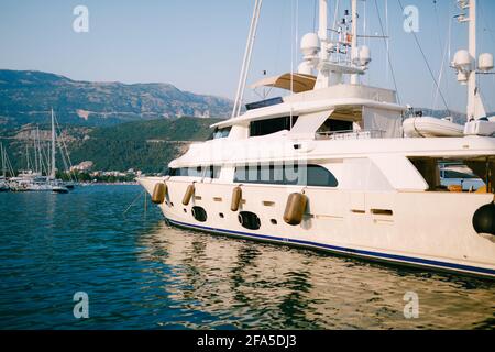 Le yacht à moteur blanc de luxe sort du quai à bateaux de Budva Monténégro Banque D'Images